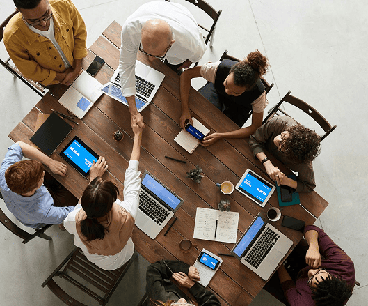 Team meeting around table with laptops